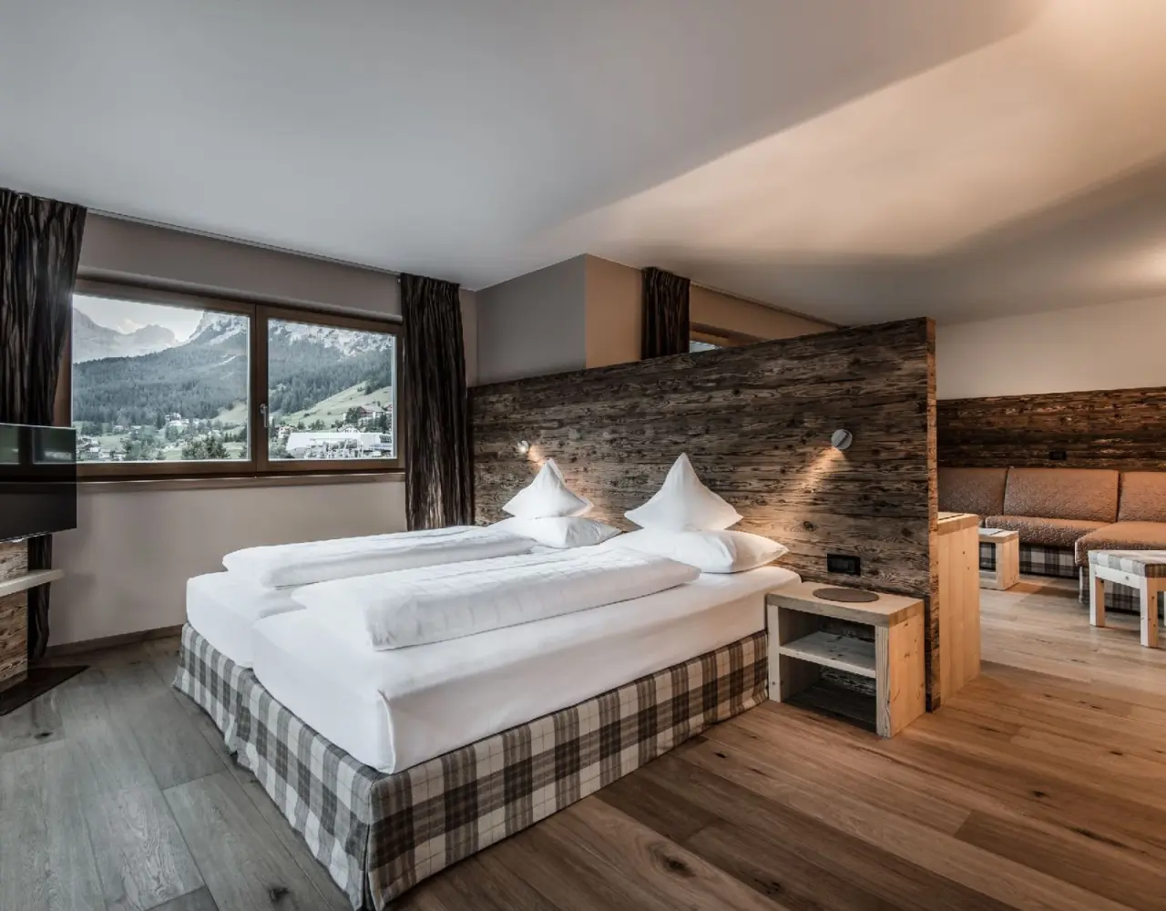 Hotel Christiania in La Villa – Komfortables Zimmer mit Bergblick und gemütlichem Sitzbereich | Wellnesshotel Dolomiten
