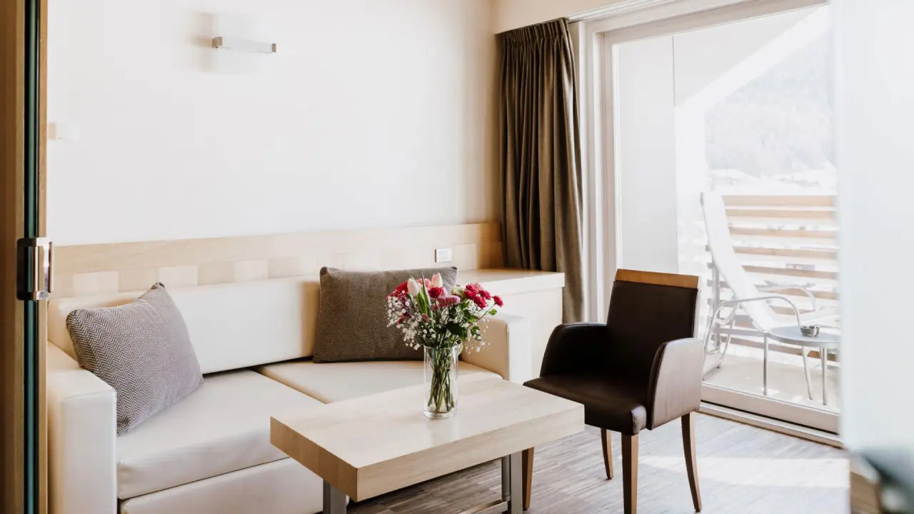 Hotel Lac Salin Spa & Mountain Resort in Livigno – Gemütlicher Wohnbereich mit Balkon und Bergblick | Wellnesshotel Livigno