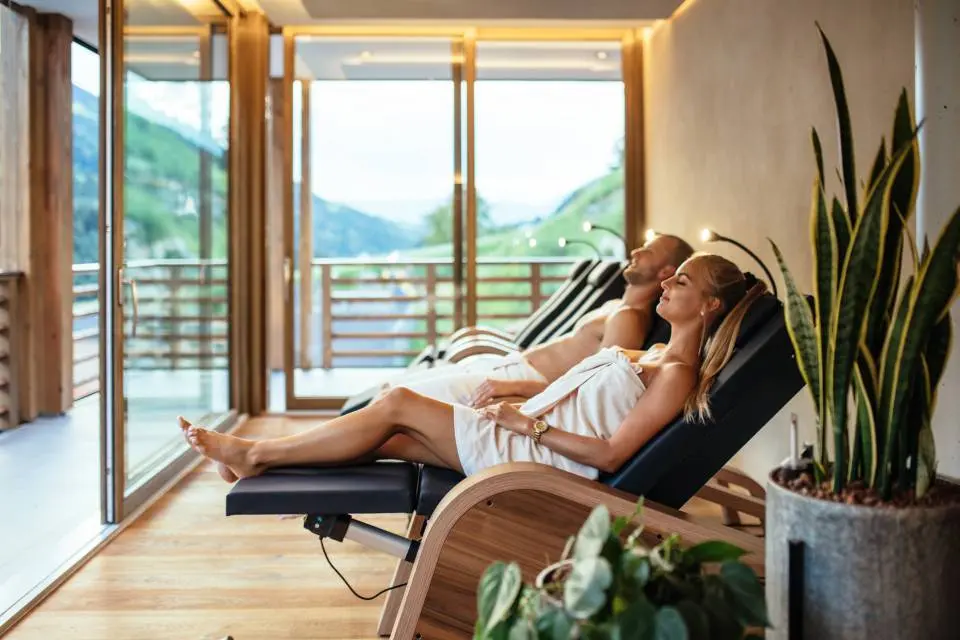 Andreus Golf Lodge in Schenna – Paar entspannt in der Wellness-Lounge mit Bergblick | Wellnesshotel Südtirol