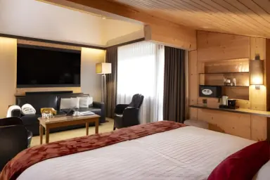 Hotel Cailler in Val-de-Charmey – Gemütliches Hotelzimmer mit Sofa und TV | Wellnesshotel Fribourg