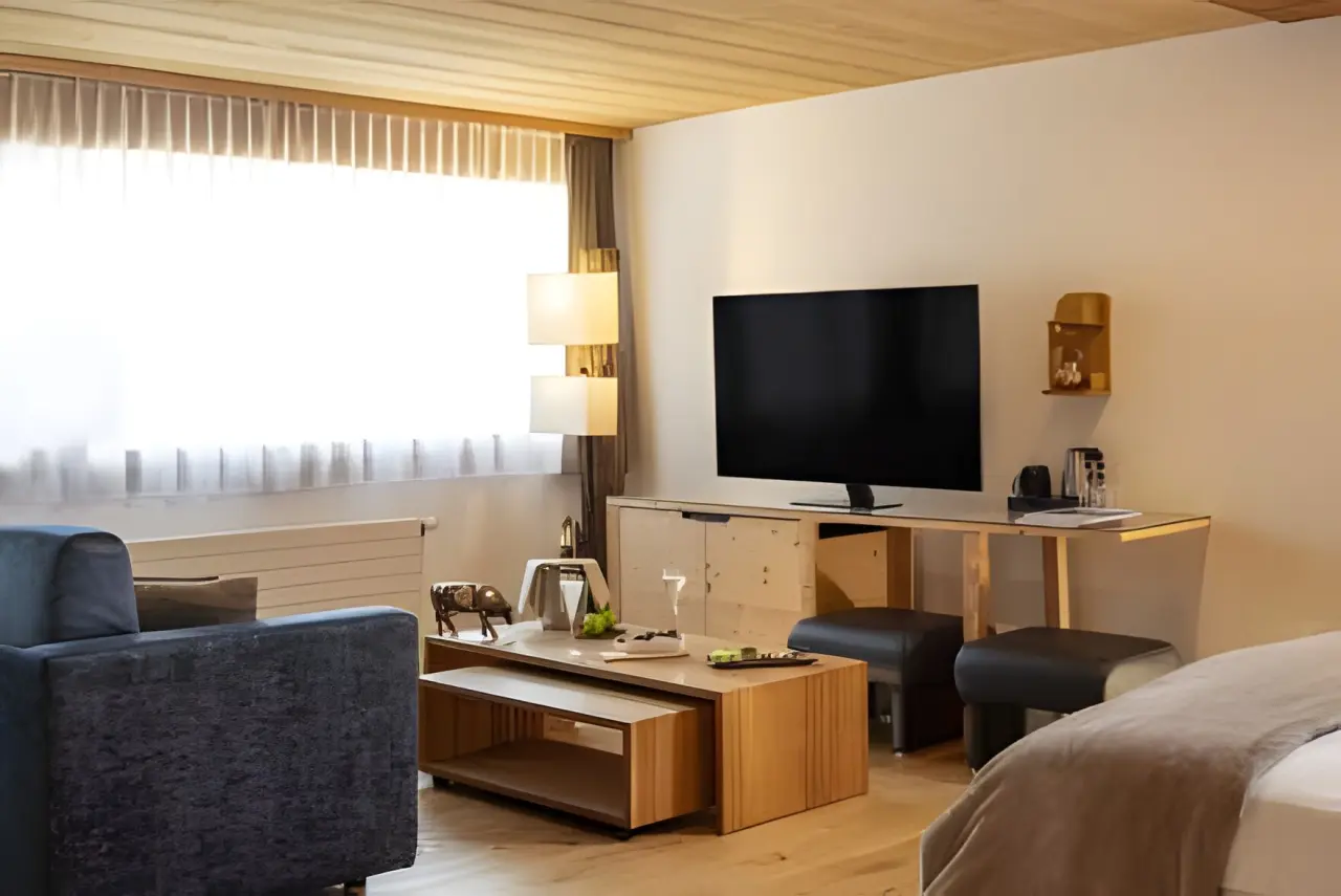Hotel Cailler in Val-de-Charmey – Helles Hotelzimmer mit Sitzbereich | Wellnesshotel Fribourg