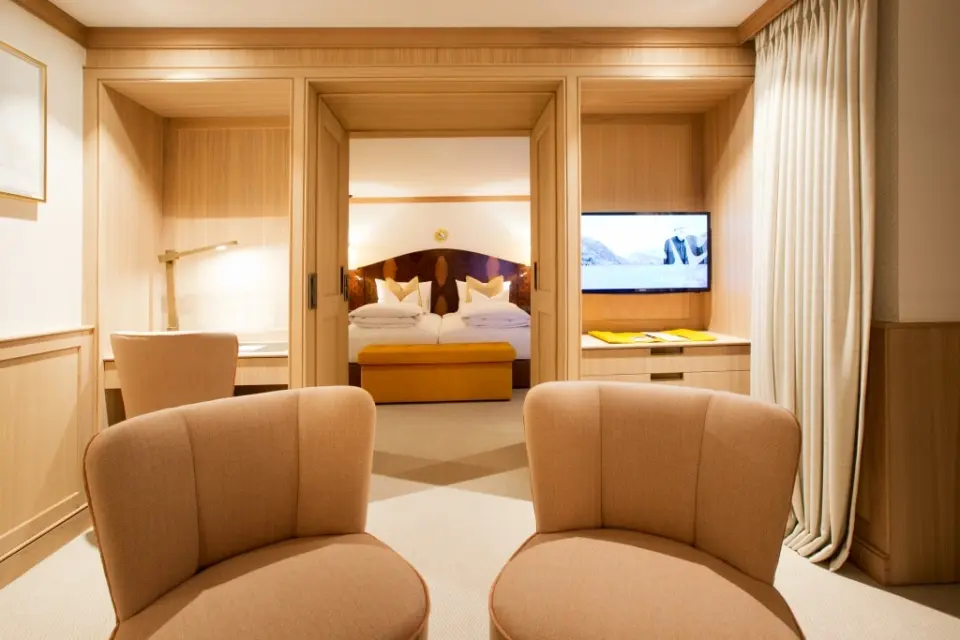 Hotel Sonnenburg in Lech am Arlberg – Komfortables Schlafzimmer einer Suite mit Doppelbett | Wellnesshotel Arlberg
