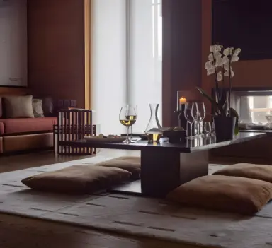 The Chedi Andermatt in Andermatt – Detailaufnahme von Wein und Orchidee auf Tisch | Wellnesshotel Schweizer Alpen