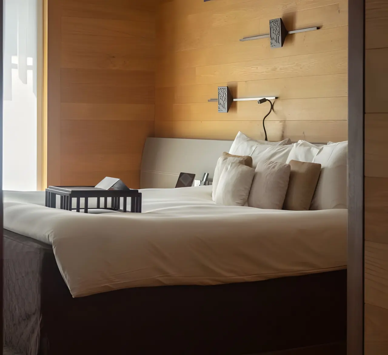 The Chedi Andermatt in Andermatt – Komfortables Hotelbett mit Holzwand | Wellnesshotel Schweizer Alpen