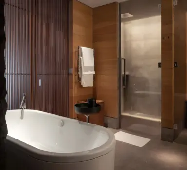 The Chedi Andermatt in Andermatt – Modernes Badezimmer mit Badewanne und Dusche | Wellnesshotel Schweizer Alpen