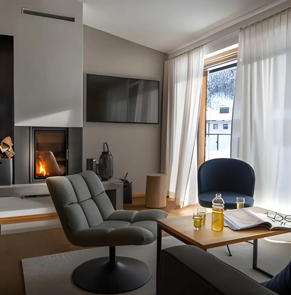 Sporthotel Silvretta Montafon in Gaschurn – Gemütliches Wohnzimmer mit Kamin und Bergblick | Wellnesshotel Montafon