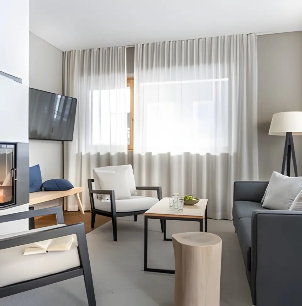 Sporthotel Silvretta Montafon in Gaschurn – Helles Wohnzimmer mit Kamin und moderner Einrichtung | Wellnesshotel Montafon