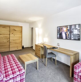 Sporthotel Silvretta Montafon in Gaschurn – Komfortables Hotelzimmer mit Schreibtisch und Sofa | Wellnesshotel Montafon
