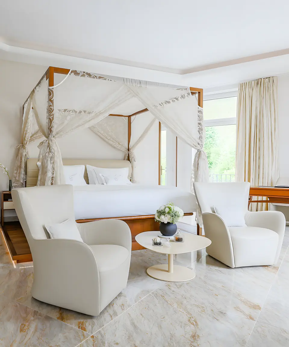 Park Hotel Vitznau in Weggis – Elegantes Schlafzimmer mit Himmelbett und Sitzbereich | Wellnesshotel Zentralschweiz
