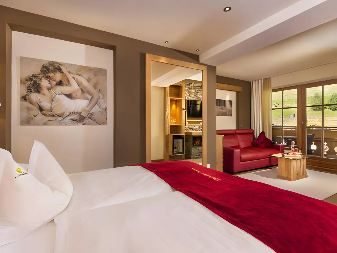 Hotel Quelle - Nature Spa Resort in St. Martin in Gsies – Schlafbereich einer Suite mit rotem Akzent | Wellnesshotel Südtirol