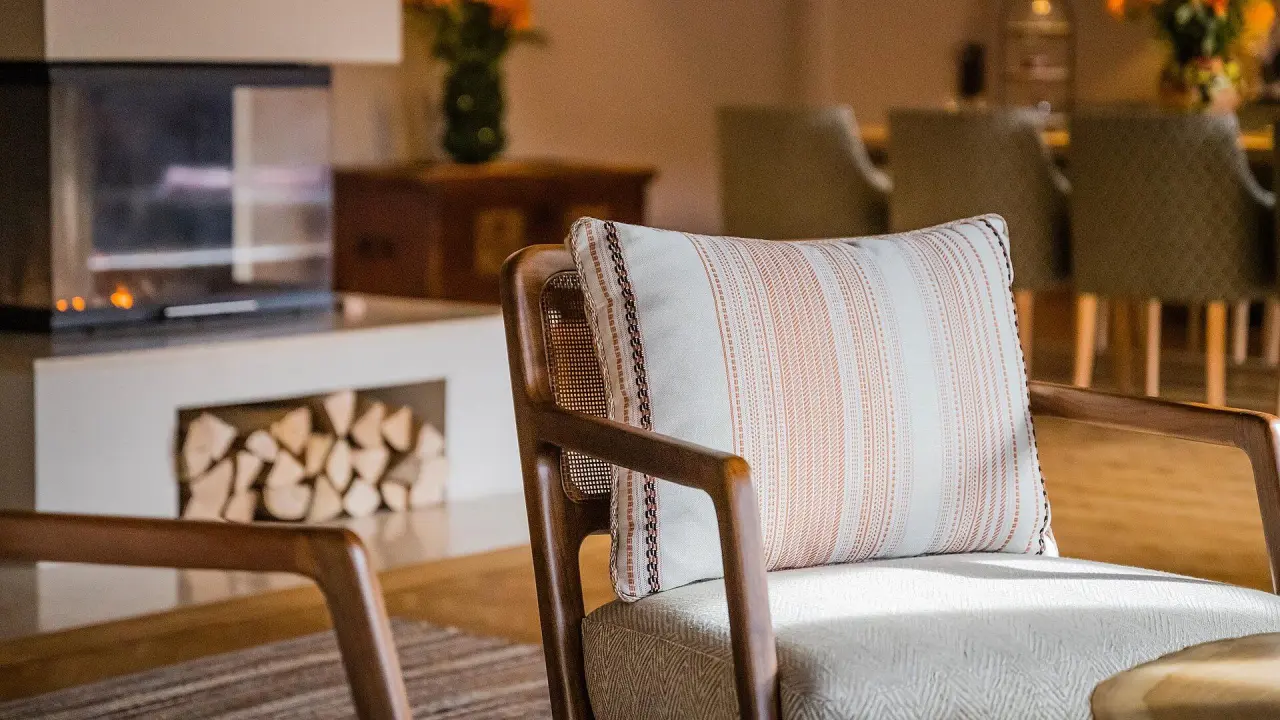Bachmair Weissach Spa & Resort in Rottach-Egern – Gemütlicher Sessel mit Kamin im Wohnbereich | Wellnesshotel Tegernsee