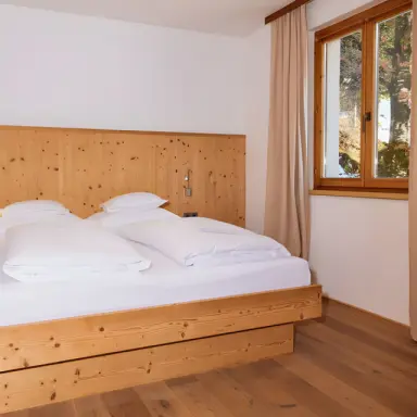 AKTIV & SPA HOTEL Alpenrose in Schruns – Helles Doppelzimmer mit Holzbett und Fensterblick | Wellnesshotel Montafon
