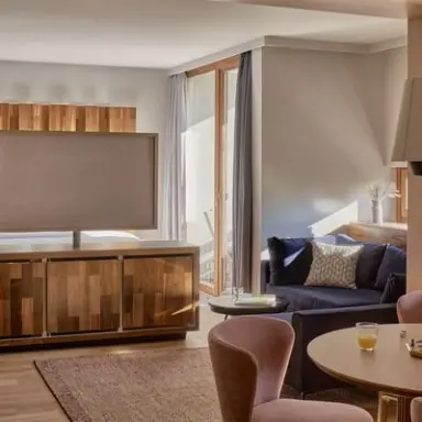 Falkensteiner Carinzia in Hermagor Naßfeld – Wohnbereich einer Suite mit großem TV | Wellnesshotel Kärnten
