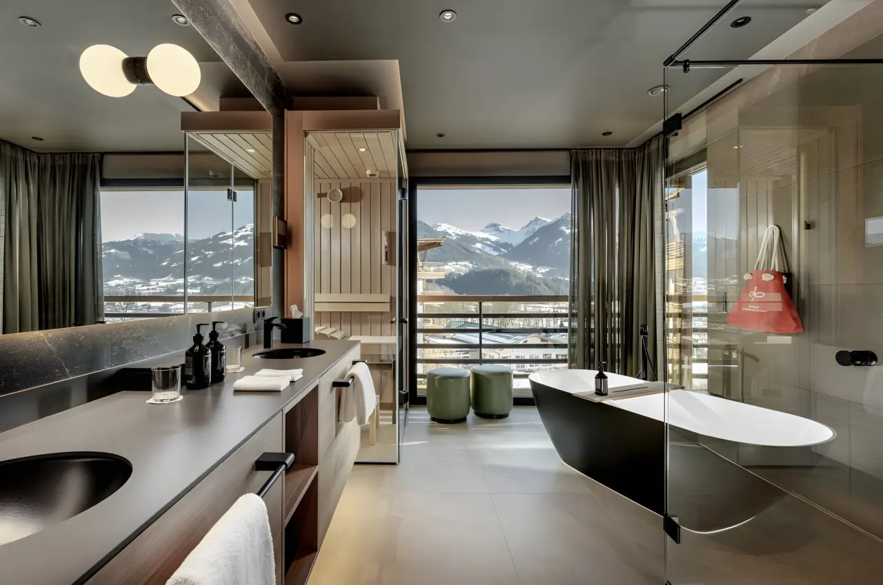 Grand Tirolia Kitzbühel in Kitzbühel – Luxus-Badezimmer mit Sauna, Wanne und Bergblick | Wellnesshotel Tirol