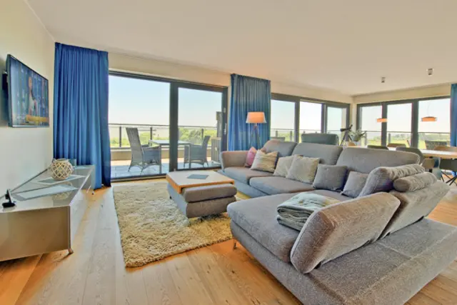 Elbstrand Resort Krautsand in Drochtersen-Krautsand – Geräumiges Wohnzimmer mit Balkon und Elbblick | Wellnesshotel Elbmarsch