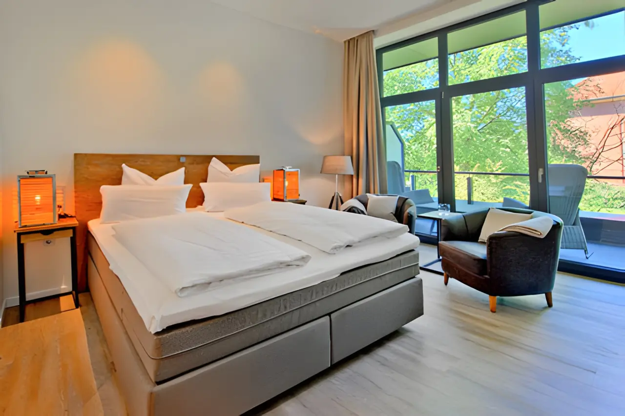 Elbstrand Resort Krautsand in Drochtersen-Krautsand – Gemütliches Schlafzimmer mit Doppelbett und Balkon | Wellnesshotel Elbmarsch