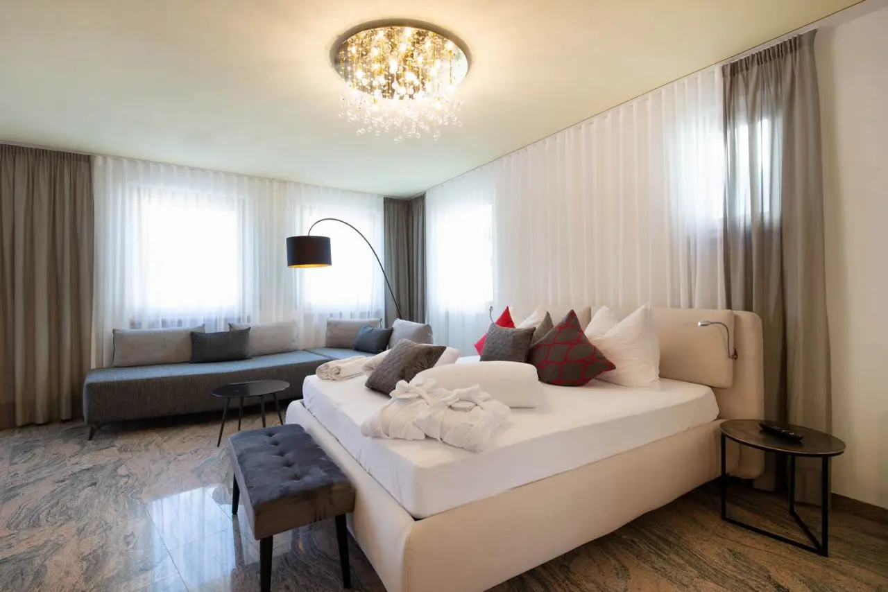 Hotel Engel in Mals – Modernes Doppelzimmer mit großem Bett und Sitzbereich | Wellnesshotel Südtirol