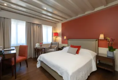 Suvretta House in St. Moritz – Modernes Doppelzimmer mit roter Akzentwand | Wellnesshotel Graubünden