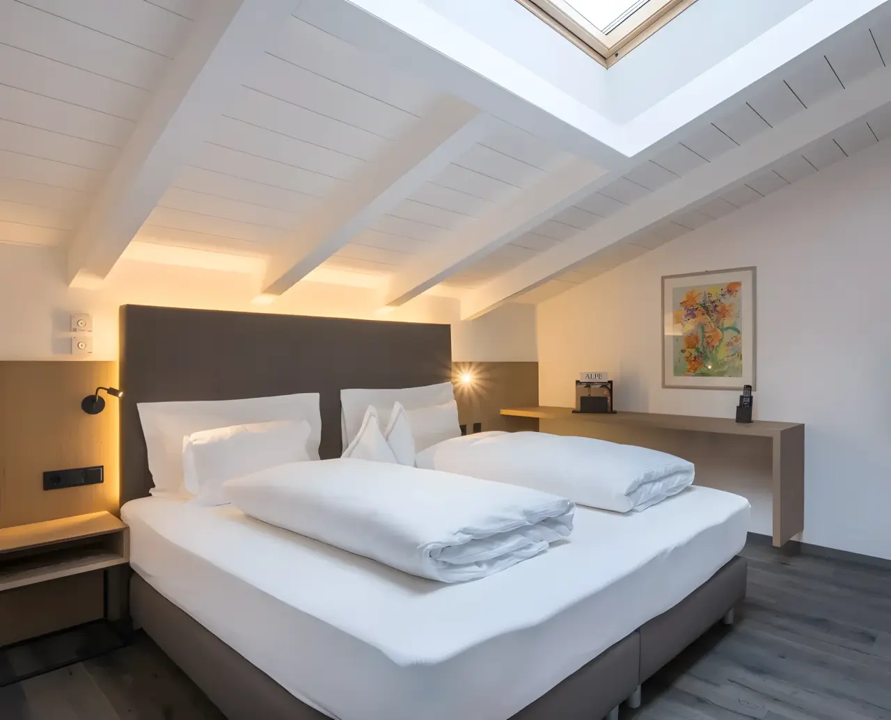 Hotel Alpenflora in Kastelruth – Gemütliches Hotelzimmer mit Dachfenster und Holzbalken | Wellnesshotel Südtirol