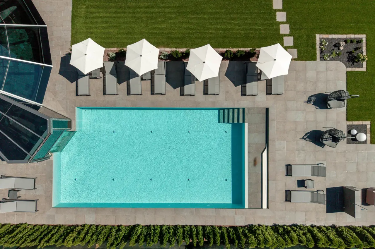 Hotel Renè in Campitello di Fassa – Luftaufnahme des Außenpools mit Liegebereich | Wellnesshotel Dolomiten