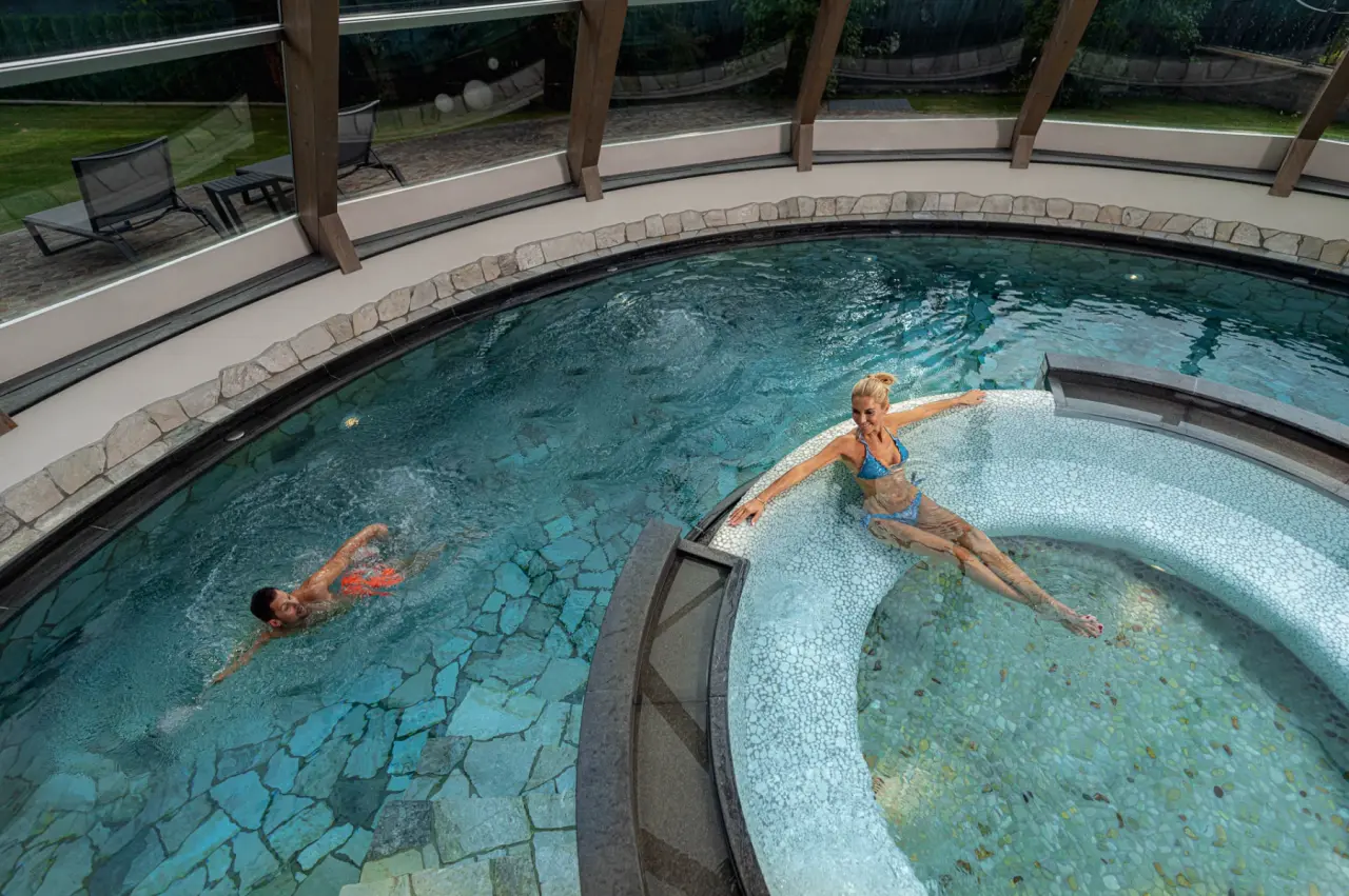 Hotel Renè in Campitello di Fassa – Paar im modernen Innenpool mit Whirlpool-Bereich | Wellnesshotel Dolomiten