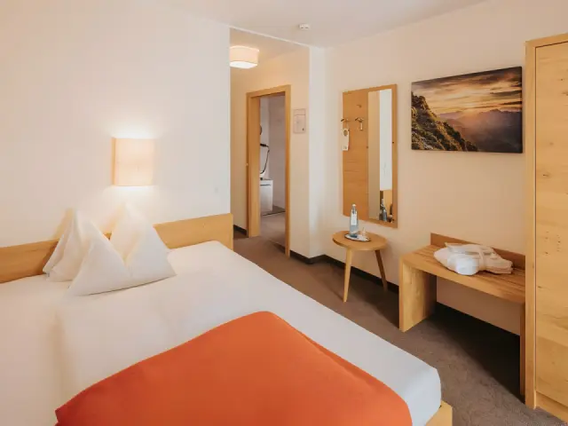 Hotel Alpenland in Obertauern – Helles Einzelzimmer mit Holzelementen und Spiegel | Wellnesshotel Salzburger Land
