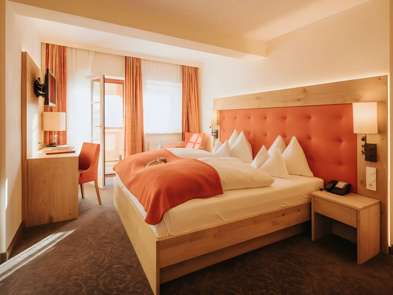 Hotel Alpenland in Obertauern – Komfortables Doppelzimmer mit orangefarbenen Akzenten | Wellnesshotel Salzburger Land