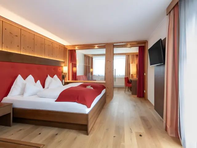 Hotel Alpenland in Obertauern – Großzügiges Hotelzimmer mit Holzwänden und separatem Wohnbereich | Wellnesshotel Salzburger Land