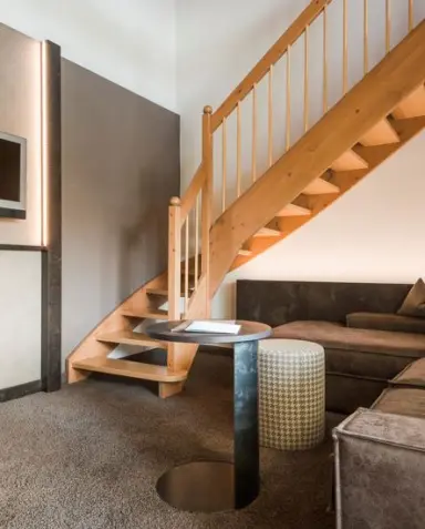 Klein Fein Hotel Anderlahn in Plaus – Hotelzimmer mit eleganter Holztreppe und Sitzbereich | Wellnesshotel Südtirol