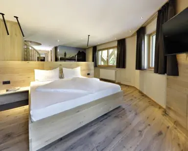 Hotel Ratschingserhof in Ratschings – Modernes Doppelzimmer mit Holzelementen und Bergblick | Wellnesshotel Südtirol