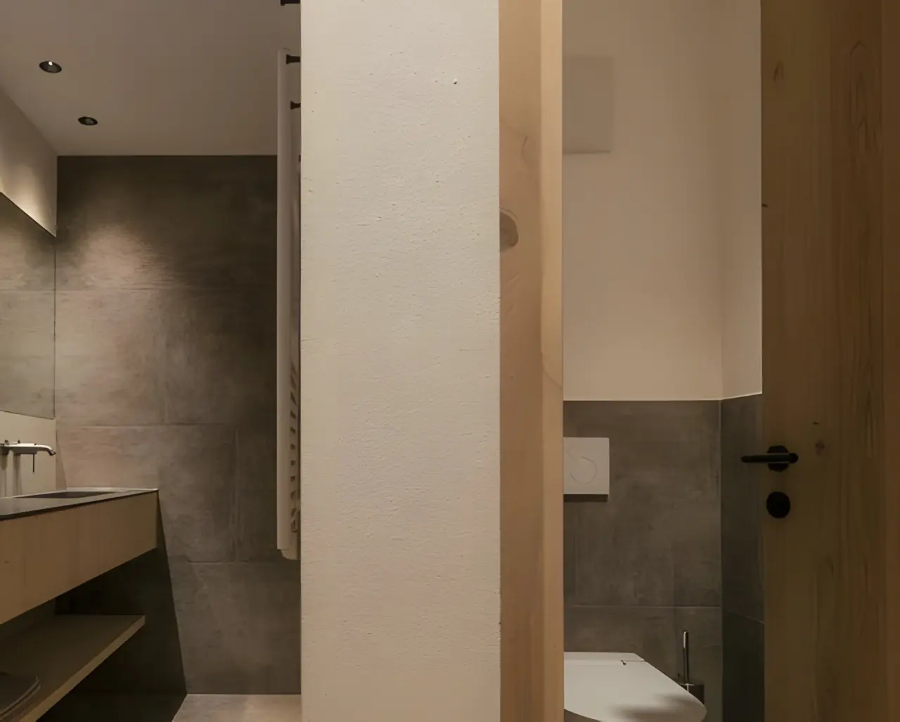 Hotel Ratschingserhof in Ratschings – Modernes Badezimmer mit dunklen Fliesen und Holzakzenten | Wellnesshotel Südtirol